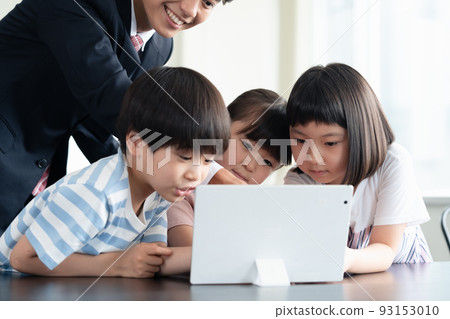 Elementary school students receiving programming education on tablets 93153010