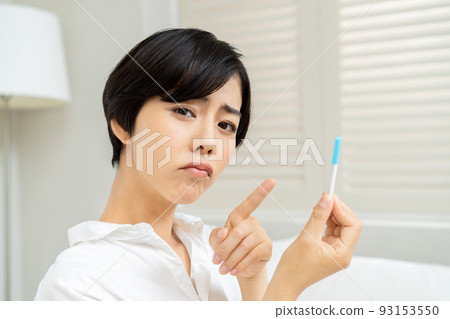 A woman looking at the results of an antigen test and a PCR test A woman looking at the results of an antigen test and a PCR test 93153550