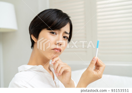 A woman looking at the results of an antigen test and a PCR test 93153551