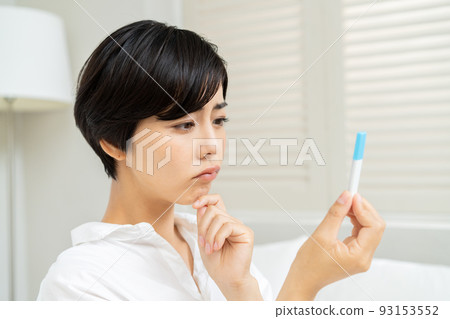 A woman looking at the results of an antigen test and a PCR test 93153552