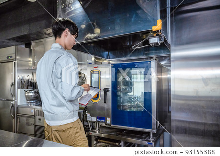 Male staff checking commercial kitchen utensils 93155388
