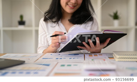 Young businesswoman using laptop and working with financial document at contemporary workplace 93156699
