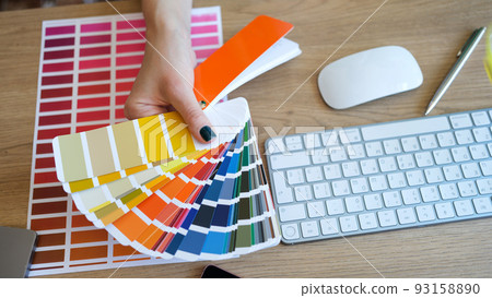 Female interior designer showing fan of colourful samples Female interior designer showing fan of colourful samples 93158890