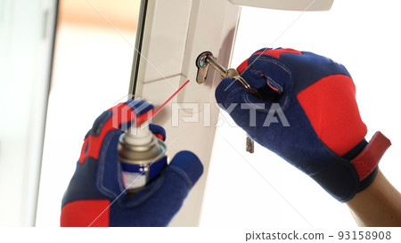 Repairman using lubricate in spray can for lock of plastic window Repairman using lubricate in spray can for lock of plastic window 93158908