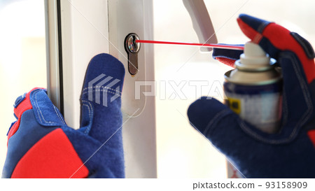 Man applying lubricate oil for lock of plastic window 93158909