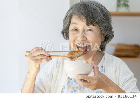 Senior woman eating tonkatsu 93160134