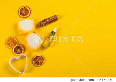 Flat lay composition with natural handmade soap and ingredients on yellow background. Space for text 93162230