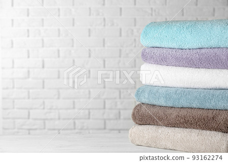 Stack of clean bath towels on white wooden table. Space for text 93162274