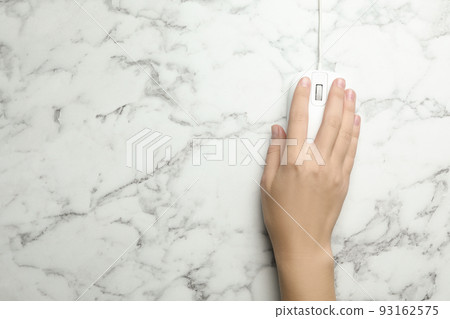 Woman using wired computer mouse on marble table, top view. Space for text Woman using wired computer mouse on marble table, top view. Space for text 93162575