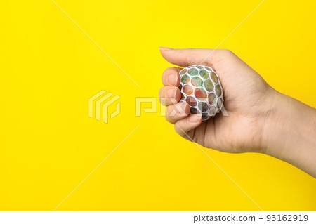 Woman holding colorful slime on yellow background, closeup. Antistress toy Woman holding colorful slime on yellow background, closeup. Antistress toy 93162919