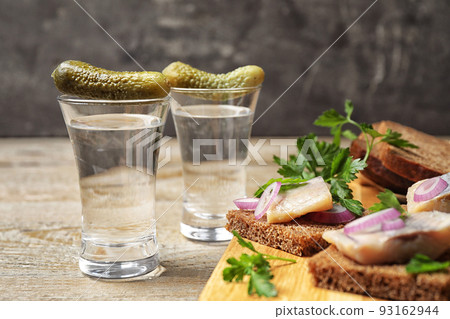 Cold Russian vodka with snacks on wooden table, closeup Cold Russian vodka with snacks on wooden table, closeup 93162944