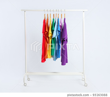 Colorful clothes hanging on rack against white background 93163088
