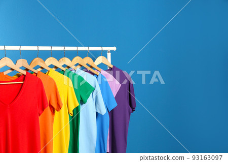 Bright clothes on blue background, space for text. Rainbow colors Bright clothes on blue background, space for text. Rainbow colors 93163097