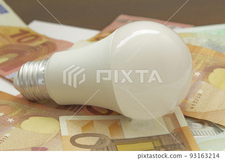 light bulb and euro banknotes. electricity price concept, increasing the energy costs, save electricity, horizontal closeup light bulb and euro banknotes. electricity price concept, increasing the energy costs, save electricity, horizontal closeup 93163214
