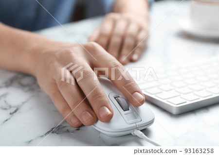 Woman using wired computer mouse at marble table, closeup Woman using wired computer mouse at marble table, closeup 93163258