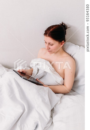 Portrait of a young beautiful brunette lying in bed wearing underwear 93164380