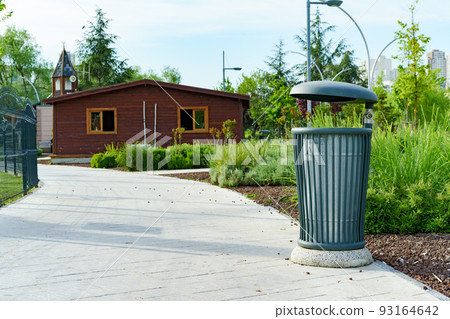 Green metal trash bin in a city 93164642