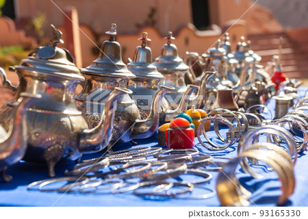 Moroccan craft souvenirs on street market. Teapots, jewelry, tagines, trinkets Moroccan craft souvenirs on street market. Teapots, jewelry, tagines, trinkets 93165330