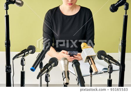 Female speaker holds press conference and using mobile phone Female speaker holds press conference and using mobile phone 93165583