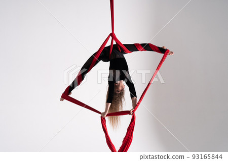 Flexible circus Artist performs on the aerial silk on white background. Concept of willpower, motivation and passion 93165844