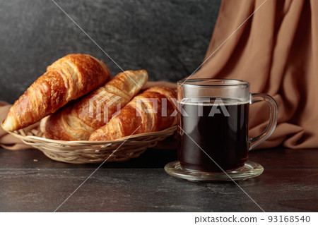 Croissants and black coffee. 93168540