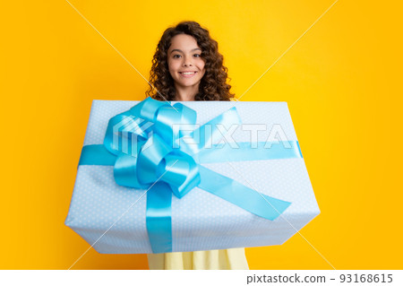 Teenager child with gift box. Present for holidays. Happy birthday, Valentines day, New Year or Christmas. Kid hold present box. Happy curly teenager portrait of smiling girl. Teenager child with gift box. Present for holidays. Happy birthday, Valentines day, New Year or Christmas. Kid hold present box. Happy curly teenager portrait of smiling girl. 93168615