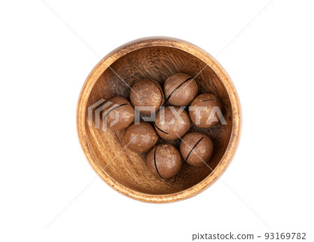 Top view of a few unpeeled macadamia nuts in a bowl over a white background. Top view of a few unpeeled macadamia nuts in a bowl over a white background. 93169782
