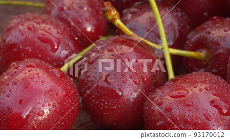 Ripe cherry in drops of water on a wooden board 93170012