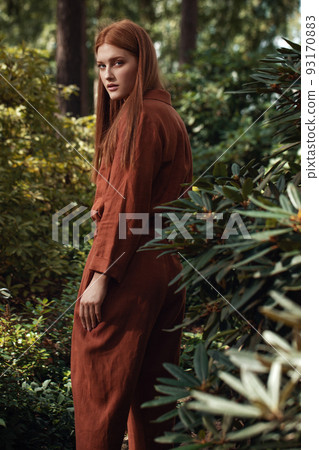 Young women with ginger hair in ecologically grown linen clothes in Japanese garden Young women with ginger hair in ecologically grown linen clothes in Japanese garden 93170883