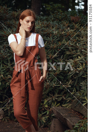 Young women with ginger hair in ecologically grown linen clothes in Japanese garden 93170884