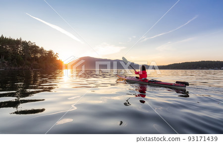 Adventurous Woman on Sea Kayak paddling in the Pacific Ocean. Adventurous Woman on Sea Kayak paddling in the Pacific Ocean. 93171439