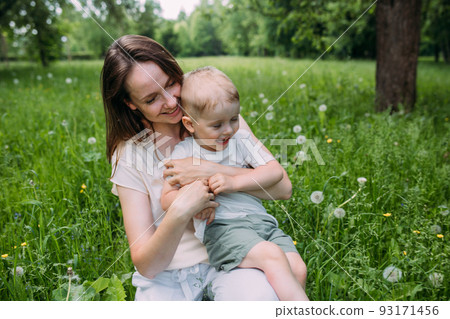 Young woman mom and son play in nature, spend time together and have fun 93171456