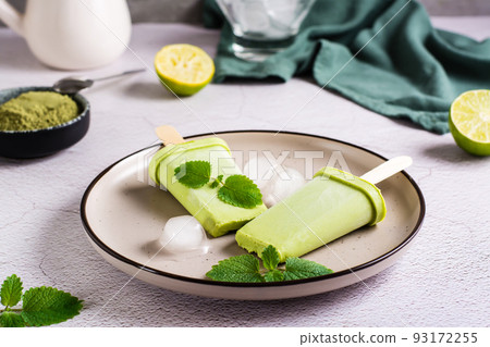 Vegetarian popsicle made from matcha tea, coconut milk and mint on a plate Vegetarian popsicle made from matcha tea, coconut milk and mint on a plate 93172255