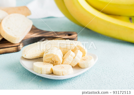 Sliced bananas on a plate prepared for making banana bread on the table. Homemade baking. Sliced bananas on a plate prepared for making banana bread on the table. Homemade baking. 93172513