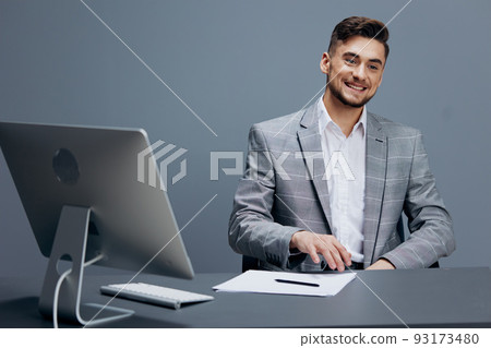 manager in a gray suit sits in front of a computer technologies manager in a gray suit sits in front of a computer technologies 93173480