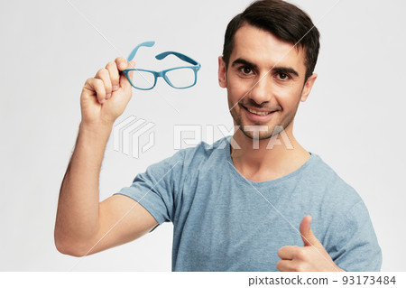 handsome man in blue t-shirt glasses gesture hands smile emotions light background handsome man in blue t-shirt glasses gesture hands smile emotions light background 93173484