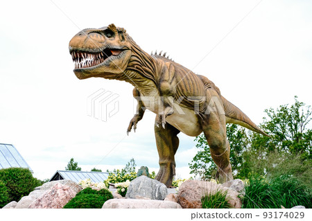 Close-up of a robotic dinosaur of the tyrannosaurus species in an amusement park Close-up of a robotic dinosaur of the tyrannosaurus species in an amusement park 93174029