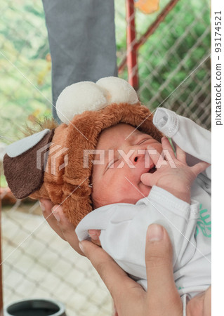 Beautiful newborn baby (4 days old), with hat and puppy shoes, in bamboo fiber basket and surrounded by green leaves, Healthy medical concept 93174521