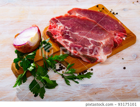 Raw pork chop on cutting board Raw pork chop on cutting board 93175101