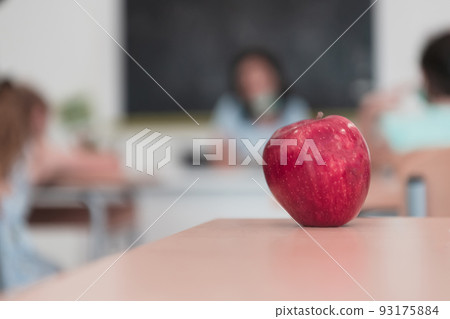 Biology and biochemistry classes. A close-up photo of a bottle containing a green plant and a ripe apple next to the bottle 93175884
