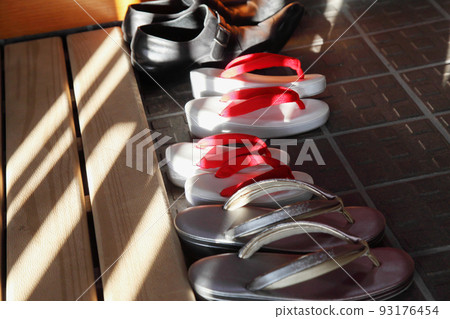 女孩和家庭涼鞋在入口處的泥地上排隊 93176454