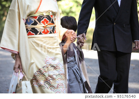 Upper body of a boy walking hand in hand with his parents in a kimono 93176540