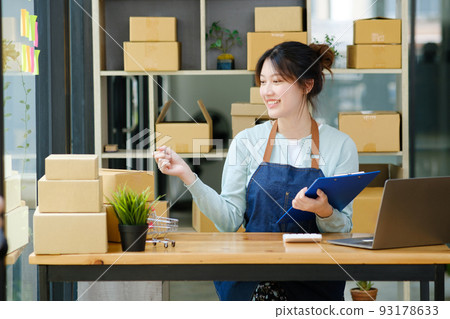 Young asian businesswoman onwer checking parcels list before delivering to customers. 93178633