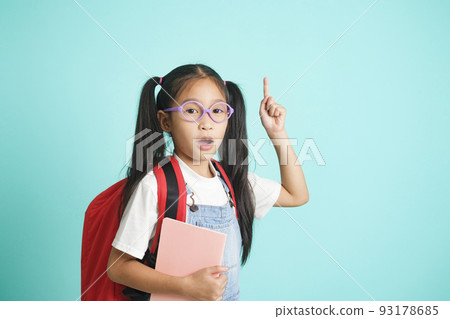 Smiling little girl in glasses pointing finger upward. Smiling little girl in glasses pointing finger upward. 93178685