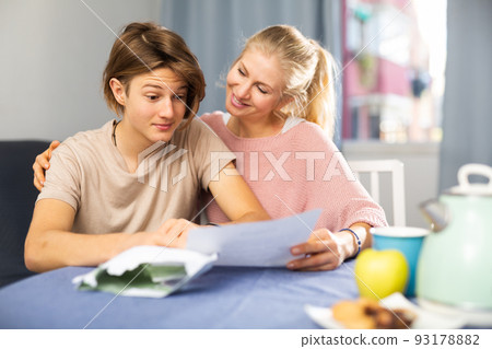 Happy mother and son reading letter from school 93178882
