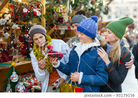 Family of four choosing decorations at Christmas fair Family of four choosing decorations at Christmas fair 93179156