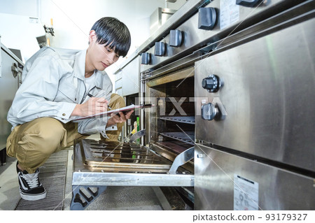 Male staff checking commercial kitchen equipment Commercial gas oven 93179327