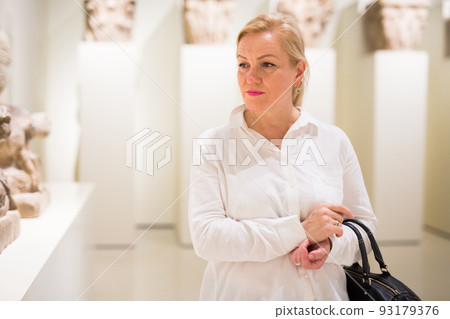 Portrait of senior woman visiting exposition at museum Portrait of senior woman visiting exposition at museum 93179376