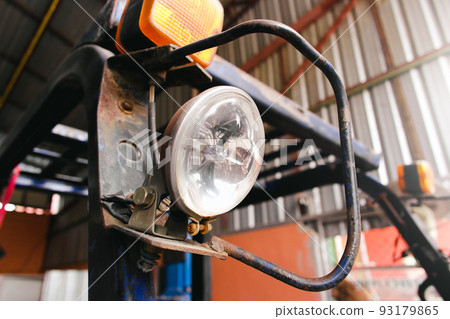 Halogen car spotlights on the forklift in the auto repair garage. Halogen car spotlights on the forklift in the auto repair garage. 93179865