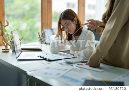 Young business woman feeling be serious, holding her head while her boss is complaining about the work. 93180710